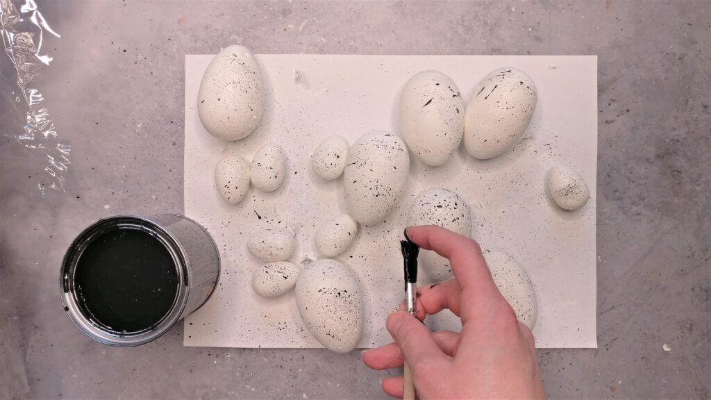 Kranz aus Ostereiern basteln Schritt 2: Schwarze Farbkleckse auf den Eier verteilen