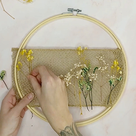 DIY Trockenblumenkranz basteln Schritt 3: getrocknete Blumen in den Stoff stecken