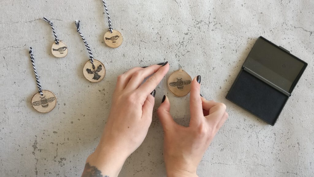 DIY Geschenkanhänger basteln Schritt 1: Die Holzscheibe mit einem Stempel deiner Wahl bestempeln