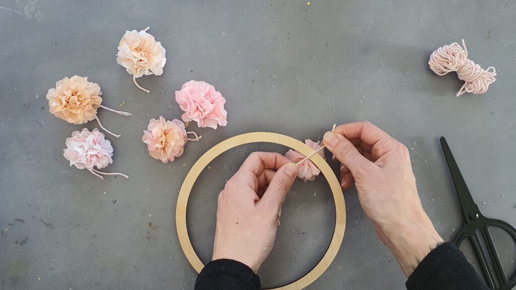 DIY Kranz mit Papierblumen Schritt 5: Blüten am Ring festknoten