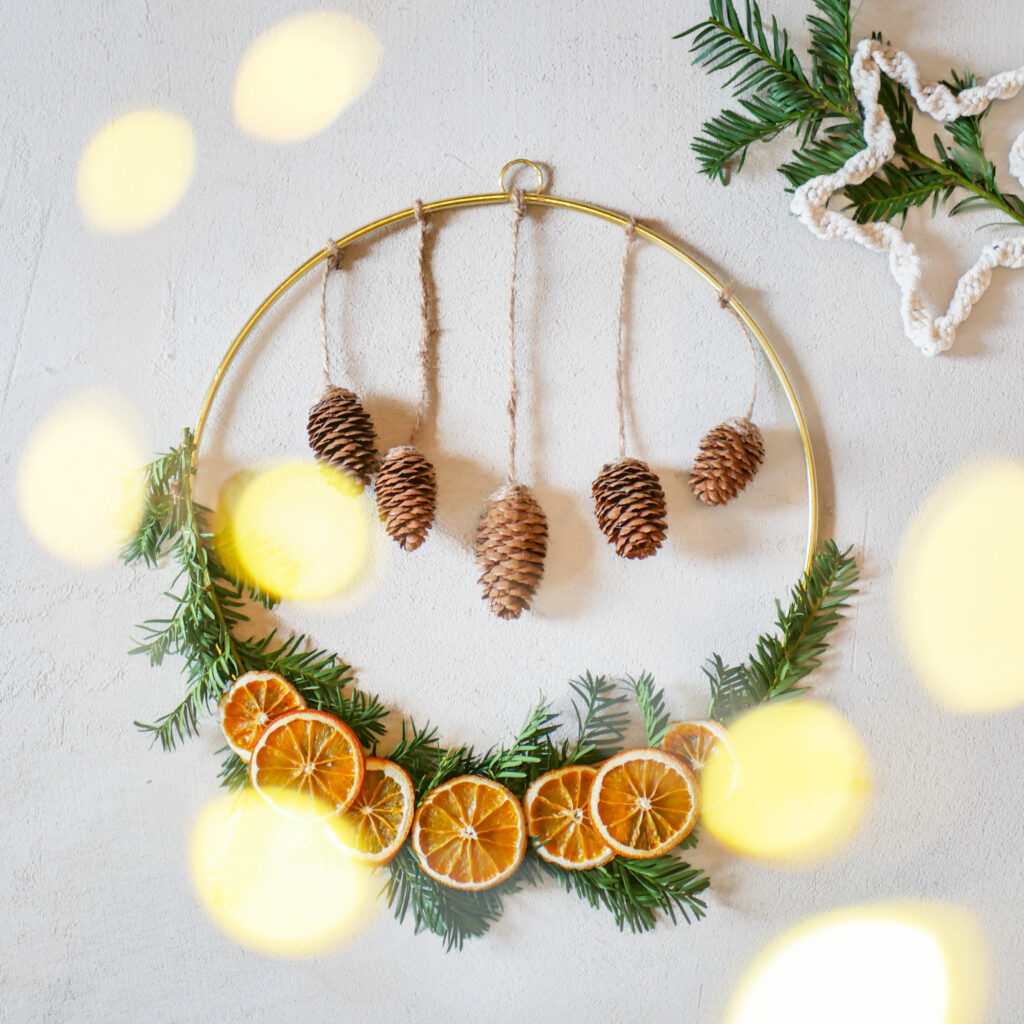 DIY Kranz für Weihnachten mit Tannenreisig, getrockneten Orangenscheiben und Zapfen