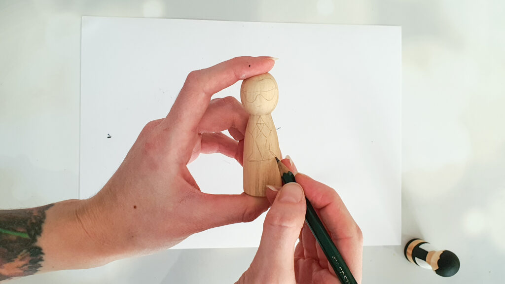 Holzfiguren bemalen Schritt 1: Mit Bleistift die Umrisse von Coco Chanel oder Karl Lagerfeld vorzeichnen