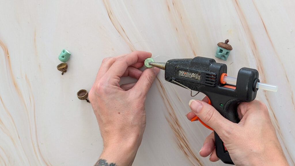 DIY Häuschen mit Eichelkappen basteln Schritt 5: Eichelhut als Dach auf das Haus kleben