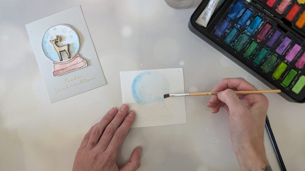Selbstgemachte Postkarte für Weihnachten Schritt 2: Schneekugel mit Wasserfarben ausmalen